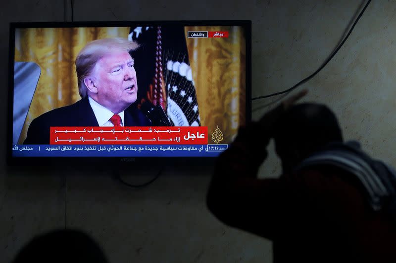 A Palestinian man watches a television screen broadcasting the announcement of Mideast peace plan by U.S. President Donald Trump, in a coffee shop in Hebron in the Israeli-occupied West Bank