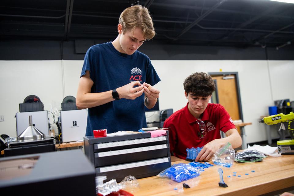 Devin Slattery, left, and Viggo De Almeida assemble laser-cut acrylic keychains and composite 3D-printed bases at Oak Ridge High on Friday, June 16, 2023. Oak Ridge High students are gaining practical, hands-on manufacturing training through the America's Cutting Edge program.