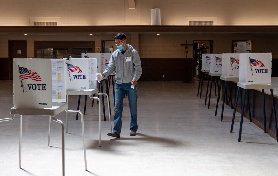 A poll worker cleans a voting booth inside St. Mary of the Nativity Catholic ChurchÕs hall during the 2022 California Primary elections in Salinas, Calif., on Tuesday, June 7, 2022. 