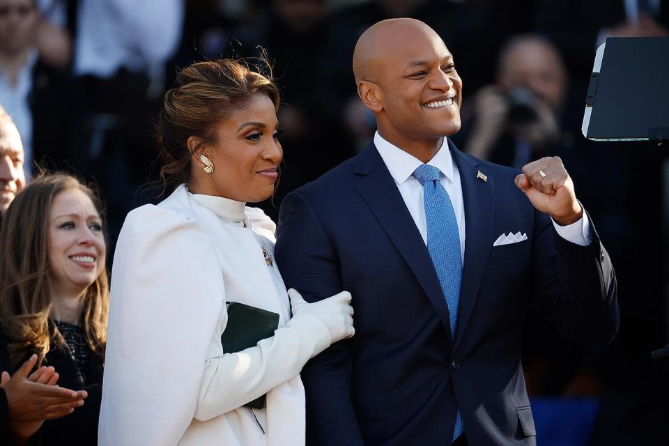 Maryland Governor Wes Moore pumps his fist as he, first lady Dawn Moore (C) and Chelsea Clinton attend his inauguration ceremony at the Maryland State House on January 18, 2023 in Annapolis, Maryland.