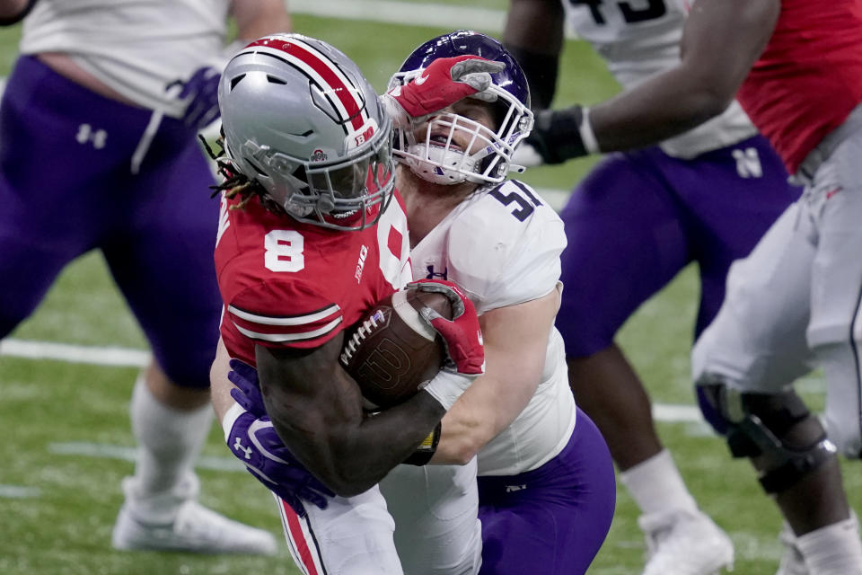 Ohio State running back Trey Sermon (8) runs with the ball as Northwestern linebacker Blake Gallagher (51) defends during the first half of the Big Ten championship NCAA college football game, Saturday, Dec. 19, 2020, in Indianapolis. (AP Photo/Darron Cummings)
