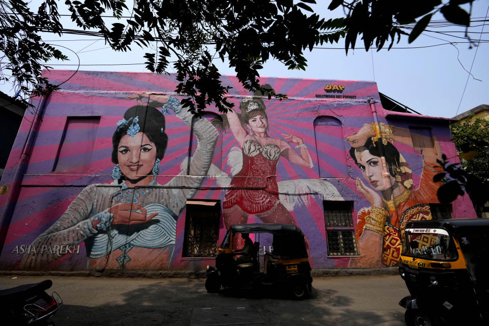 Autorickshaws drive past a mural of a Bollywood actress at Bandra in Mumbai, India, Friday, March 17, 2023. India will soon eclipse China to become the world's most populous country, and its economy is among the fastest-growing. But the number of Indian women in the workforce, already among the 20 lowest in the world, has been shrinking for decades. (AP Photo/Rajanish Kakade)