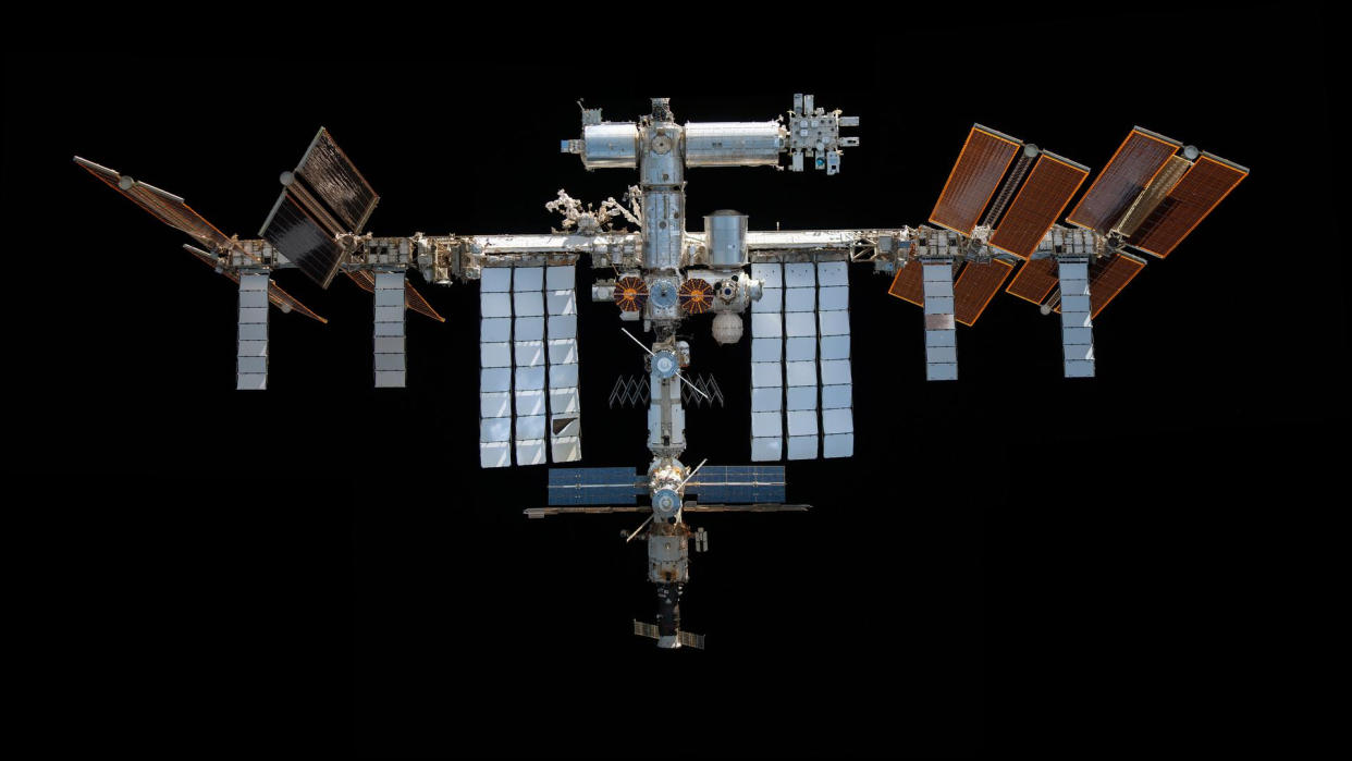  A space station hangs in black. 