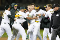 Oakland Athletics' Lawrence Butler, center, celebrates with teammates after driving in the winning run during the 10th inning of the team's baseball game against the Washington Nationals in Oakland, Calif., Friday, April 12, 2024. (AP Photo/Tony Avelar)