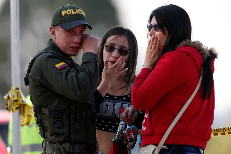 Imagen de archivo de un policía secándose las lágrimas junto a dos mujeres cerca del lugar de un ataque con coche bomba en Bogotá, Colombia.