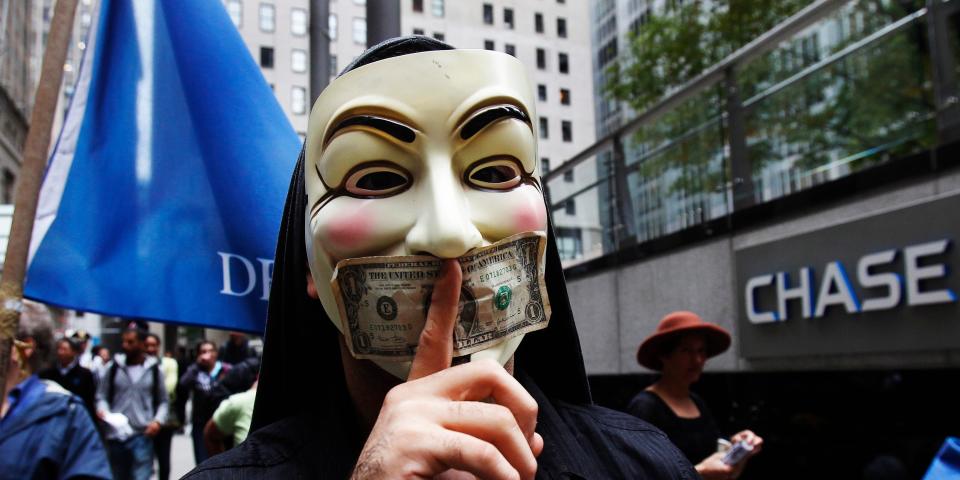 A man wearing a Guy Fawkes mask stands outside of a Chase Bank in Manhattan during the Occupy Wall Street protest.