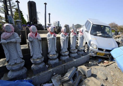 Photo taken on May 5 shows a vehicle sitting over tombstones at the graveyard of Kyudenji temple in the tsunami-devastated city of Ishinomaki, Miyagi prefecture. A year after whole neighbourhoods full of people were killed by the Japanese tsunami, rumours of ghosts swirl in Ishinomaki as the city struggles to come to terms with the awful tragedy