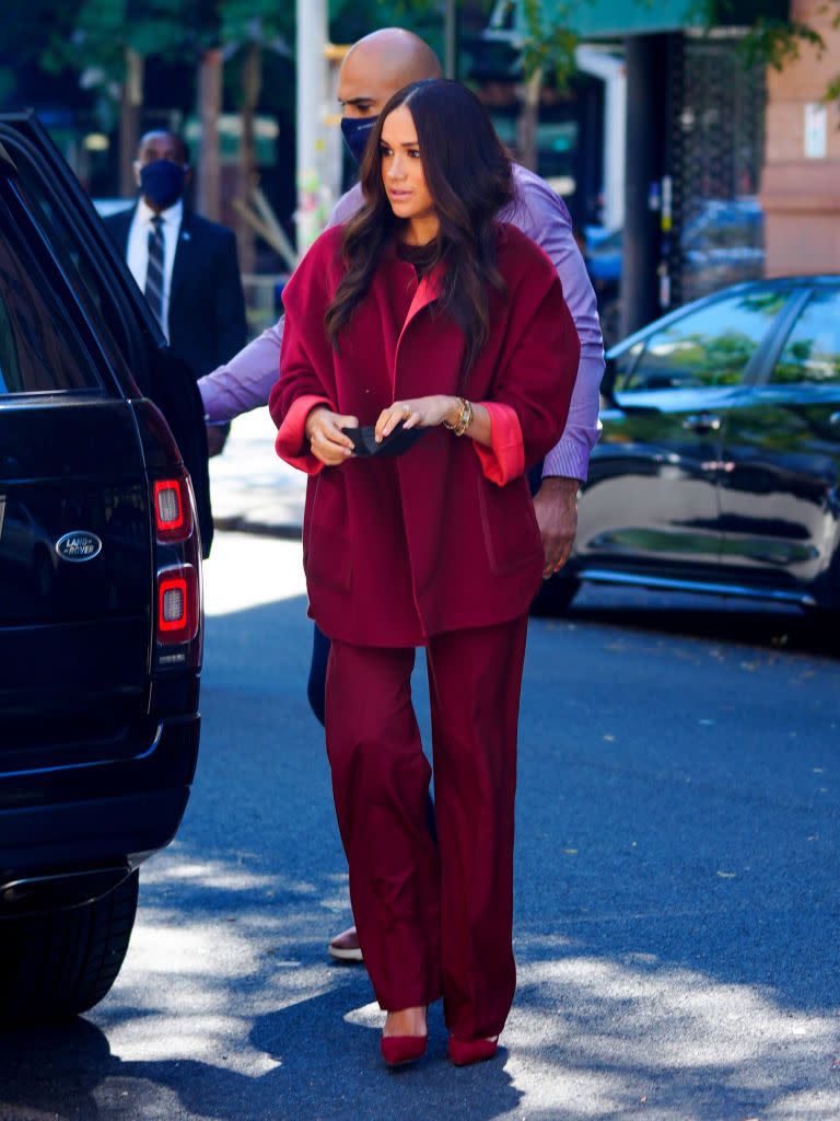 <p>For a visit to a school in Harlem during her and husband Prince Harry's trip to New York the Duchess of Sussex stepped into and effortlessly chic maroon two-piece by Loro Piana. Featuring a 1980s oversized fit, the mother-of-two turned the cuffs up on the reversible jacket to give it a casual feel. The brunette paired the high-waisted, wide-leg trousers with matching-hued heels. </p><p><a class="link " href="https://www.net-a-porter.com/en-gb/shop/designer/loro-piana" rel="nofollow noopener" target="_blank" data-ylk="slk:SHOP LORO PIANA NOW;elm:context_link;itc:0;sec:content-canvas">SHOP LORO PIANA NOW</a></p>