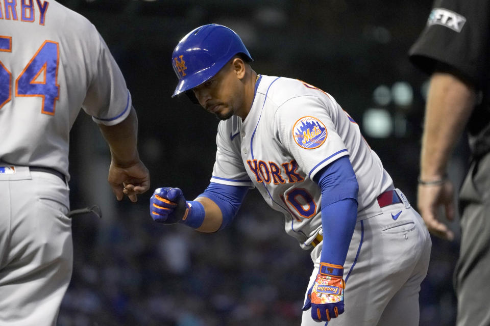 New York Mets' Eduardo Escobar celebrates his RBI single off Chicago Cubs starting pitcher Keegan Thompson with first base coach Wayne Kirby during the fifth inning of a baseball game Thursday, July 14, 2022, in Chicago. (AP Photo/Charles Rex Arbogast)