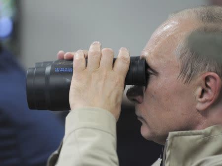 FILE PHOTO: Russian President Vladimir Putin uses a pair of binoculars to observe troops in action during a training exercise named Kavkaz 2012 in Krasnodar region, Russia, September 17, 2012. Sputnik/Alexei Druzhinin/Kremlin/File Photo via REUTERS