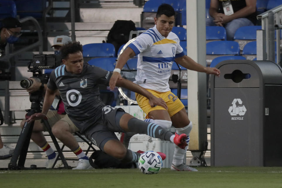 Minnesota United midfielder Hassani Dotson, left, and San Jose Earthquakes defender Nick Lima battle for the ball during the first half of an MLS soccer match, Saturday, Aug. 1, 2020, in Kissimmee, Fla. (AP Photo/John Raoux)