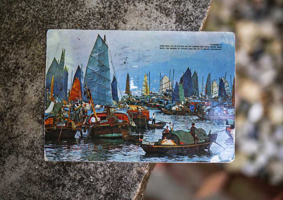 Kim Draper received a postcard, which depicts a scene of fishing boats in Hong Kong, at her home in Springfield on July 8, 2019 that was postmarked and sent from Hong Kong exactly 26 years ago on July 8, 1993 to a previous family that lived at her address. Draper is trying to track down the family that the postcard was sent to, which was addressed to Leena and Muhammad Ali Kizilbash and is signed "See you guys soon. Your Dad." (Justin L. Fowler/The State Journal-Register via AP)