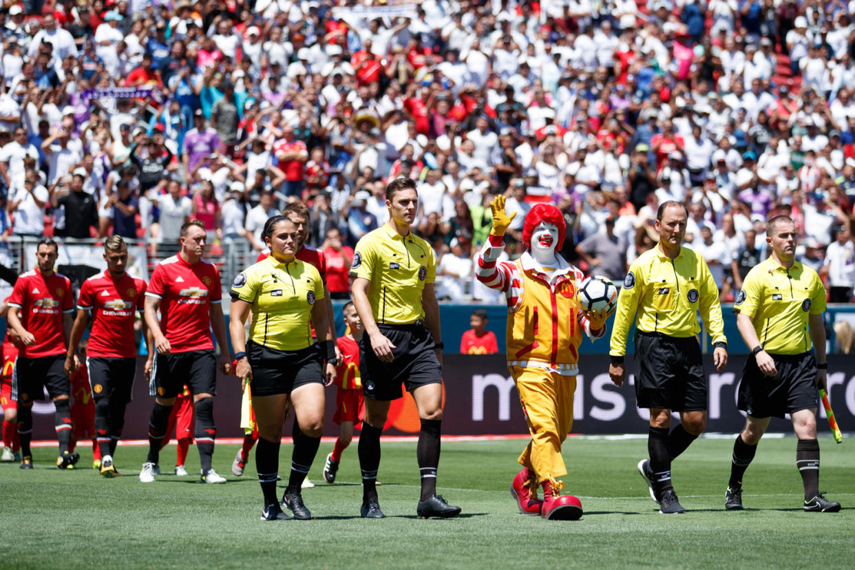 Ronald McDonald salutes the crowd as he takes to the field: Jay Barratt/AMA/Getty Images