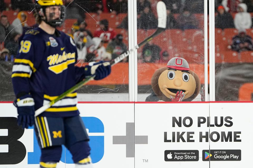 Feb 18, 2023; Cleveland, Ohio, USA;  Brutus Buckeye watches Michigan Wolverines forward Adam Fantilli (19) during third period of the Faceoff on the Lake outdoor NCAA men’s hockey game at FirstEnergy Stadium. Ohio State won 4-2. Mandatory Credit: Adam Cairns-The Columbus Dispatch