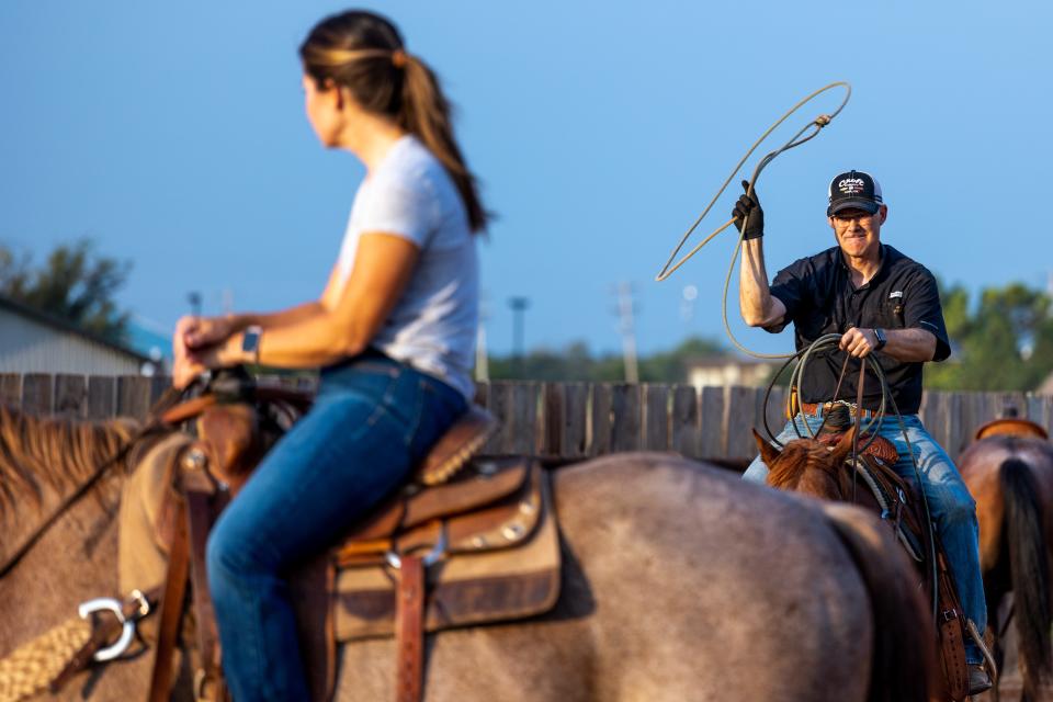 Jacob Mendenhall playfully pretends to rope his wife, Leslie Ann Mendenhall, at his home in Oklahoma City.