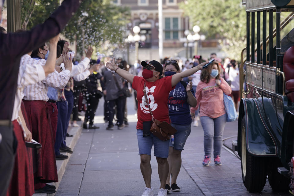 Guests walk down Main Street USA at Disneyland in Anaheim, Calif., Friday, April 30, 2021. The iconic theme park in Southern California that was closed under the state's strict virus rules swung open its gates Friday and some visitors came in cheering and screaming with happiness. (AP Photo/Jae Hong)