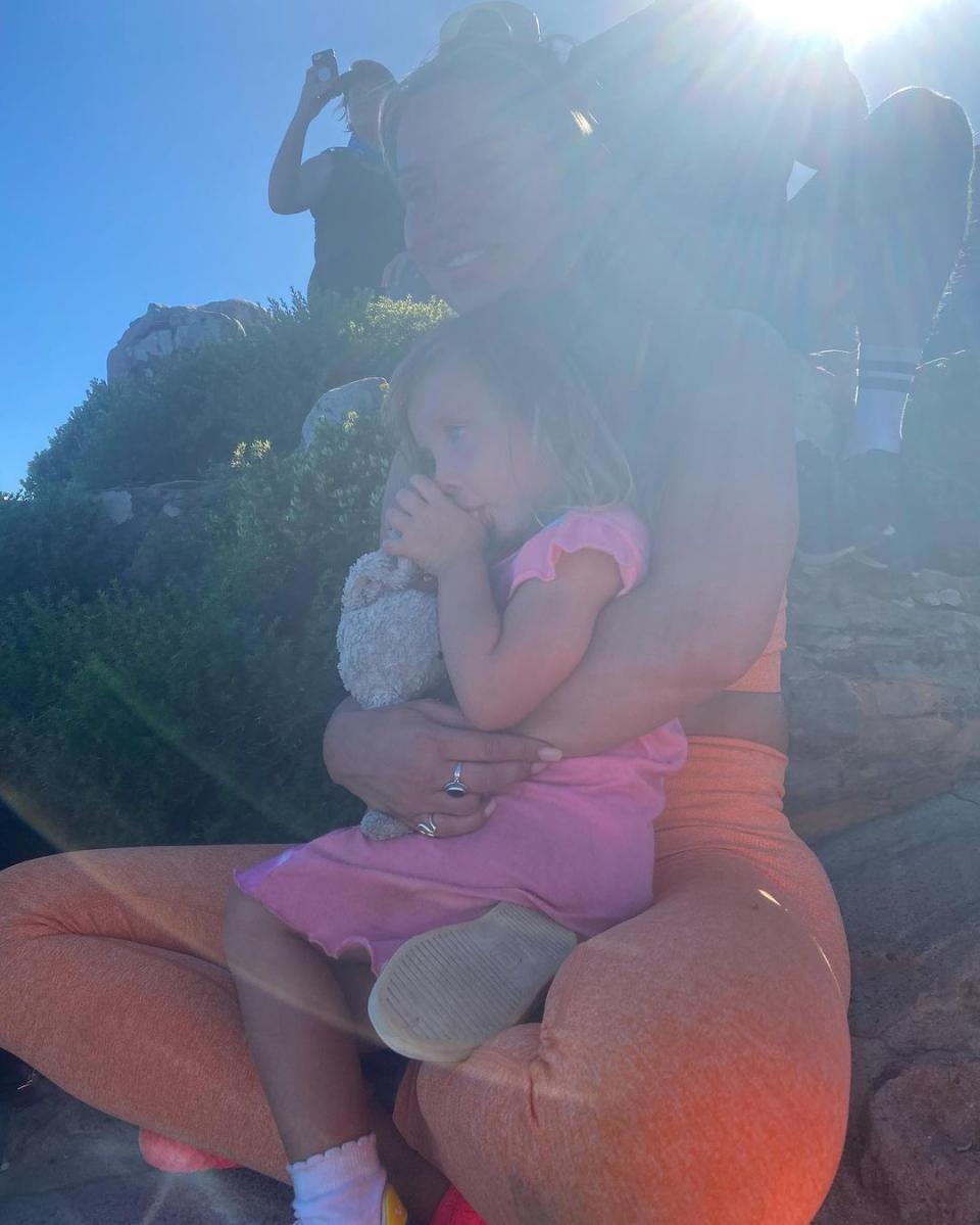 Ferne McCann in orange workout gear on a mountain in South Africa with her daughter Sunday