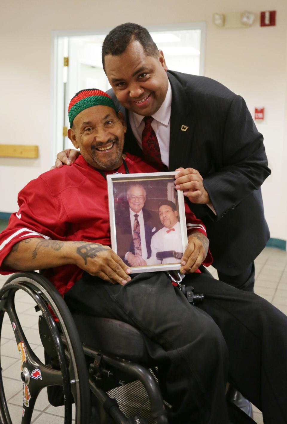 Lawrence Dilworth, 73, gets his photo taken with Sen. Coleman Young II holding a photograph of himself with the senator's father, former Detroit mayor Coleman Young, at Eden Manor, a senior citizen housing development during a campaign stop in Detroit on Oct. 30, 2017.