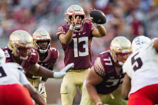 Jordan Travis catches the snap in the shotgun formation 