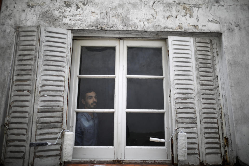 Horacio Bonafina poses for a photo from inside his home during a government-ordered lockdown to curb the spread of the new coronavirus in Buenos Aires, Argentina, Monday, June 29, 2020. Bonafina, a 36-year-old psychologist, says the quarantine has allowed him to relax and hopes to continue working for home after it's lifted. (AP Photo/Natacha Pisarenko)