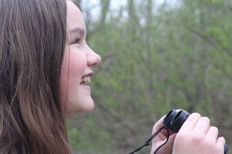 Jordan Miller, 11, birdwatches in her back yard in Manlius