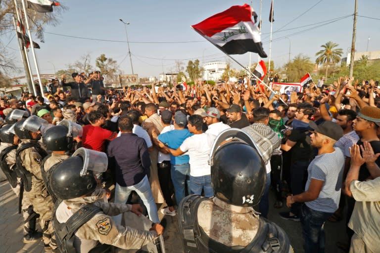 Dozens of Iraqis shout slogans and wave national flags during a demonstration outside the local government headquarters in the southern city of Basra on July 13, 2018 as they protest against poor services, unemployment, and corruption