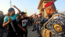 Police officers stand guard during an anti-government protest in front of the Governorate building in Basra, Iraq December 14, 2018. REUTERS/Essam al-Sudani