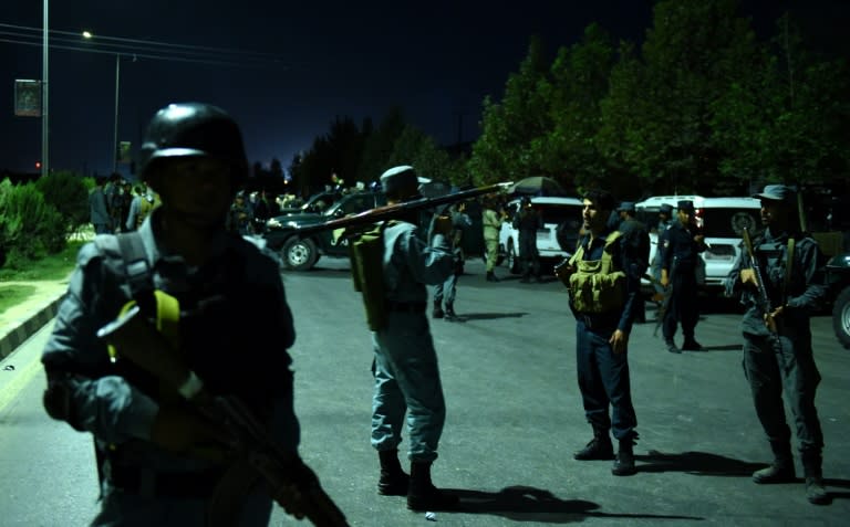 An Afghan security personnel (C), holding a rocket-propelled grenade, stands guard near the site of explosion that targeted the elite American University of Afghanistan in Kabul on August 24, 2016