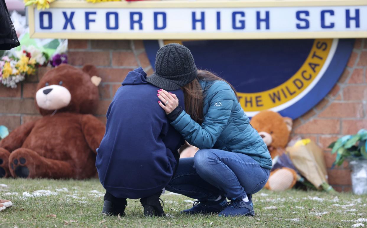  People embrace as they visit a makeshift memorial outside of Oxford High Schoo - Scott Olson/Getty