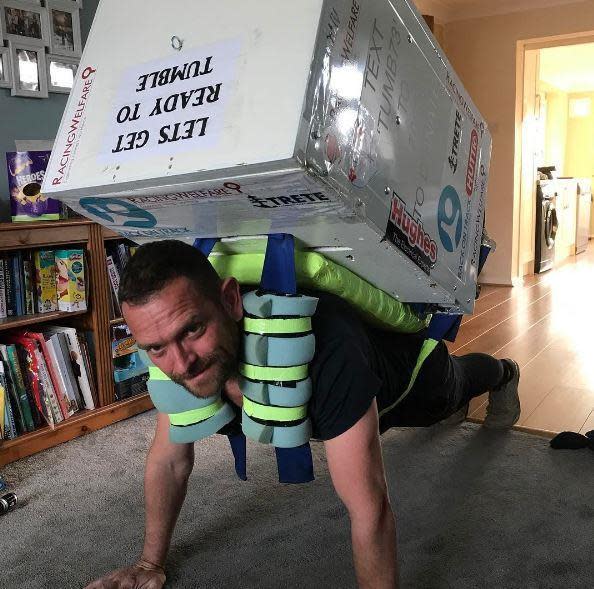 Ben Blowes preparing for the London Marathon with a tumble dryer strapped to his back