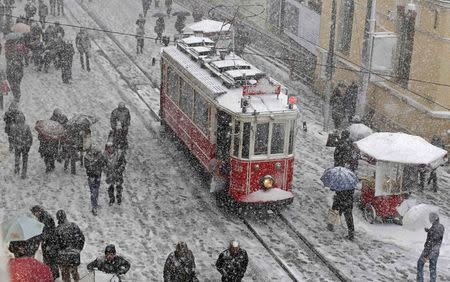 People brave the cold and snow as they walk in the main pedestrian street of Istiklal in central Istanbul February 17, 2015. REUTERS/Murad Sezer