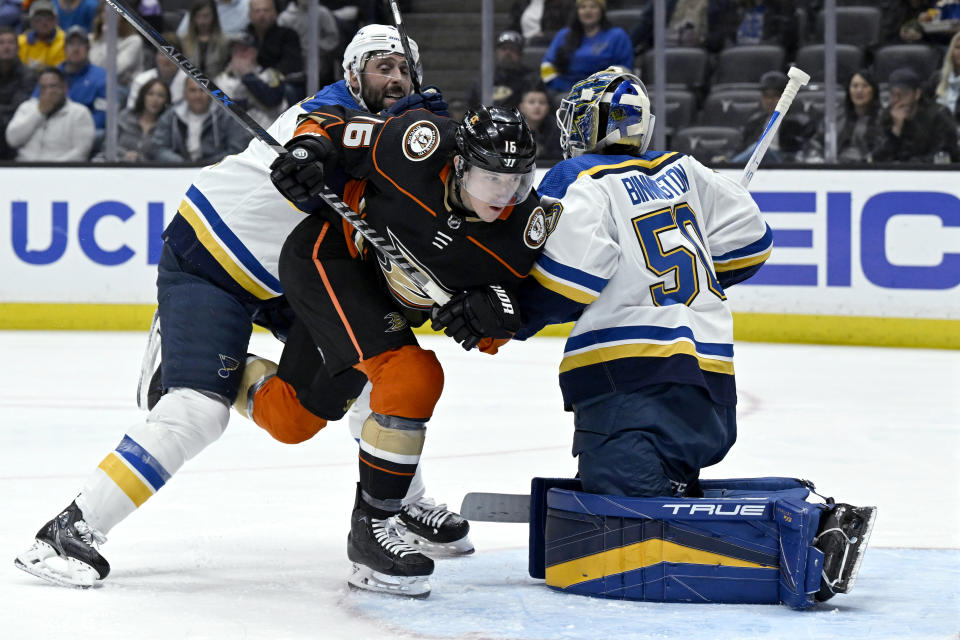 St. Louis Blues defenseman Robert Bortuzzo, left, shoves Anaheim Ducks center Ryan Strome, center, past goaltender Jordan Binnington during the second period of an NHL hockey game in Anaheim, Calif., Saturday, March 25, 2023. (AP Photo/Alex Gallardo)