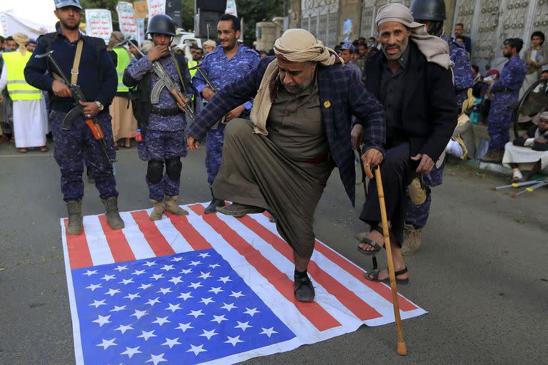 Yemeníes pisan una bandera estadounidense durante una manifestación el 23 de enero de 2023 en la capital, Sanaa, para condenar la quema del Corán por parte de un político sueco.