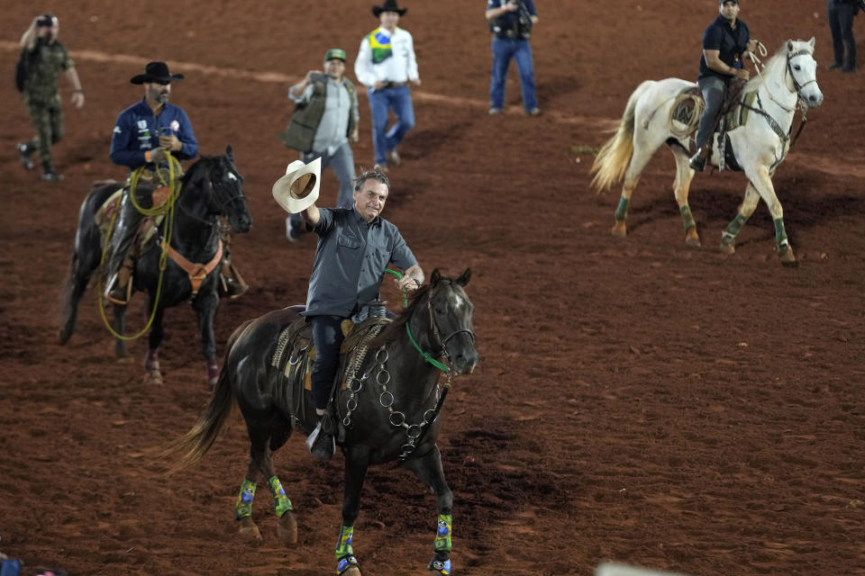 FILE - Brazilian President Jair Bolsonaro, who is running for a second term, rides a horse at the the Barretos Rodeo International Festival in Barretos, Sao Paulo state Brazil, Aug. 26, 2022. Bolsonaro is betting on a program crafted to distribute land ownership to thousands of rural farmers as a tool to win over some countryside voters and eventually beat Luiz Inacio Lula da Silva in the Oct. 2, 2022 election. (AP Photo/Andre Penner, File)