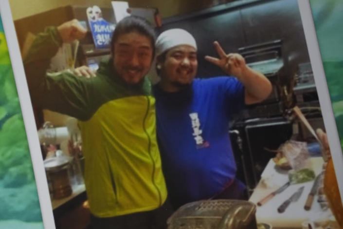 This photo provided by family courtesy shows Yoshihiko Takeuchi, right, posing for a photo with his friend Tomoyuki Kitatani, who visited Takeuchi's restaurant in Naha on the Okinawa islands, southern Japan, in 2015. Takeuchi was diagnosed with the coronavirus this year. When he didn't answer calls from public health workers for three days, police went to his home and found him dead in his bed. He was 43. (Kayoko Kitatani/Family Courtesy via AP)