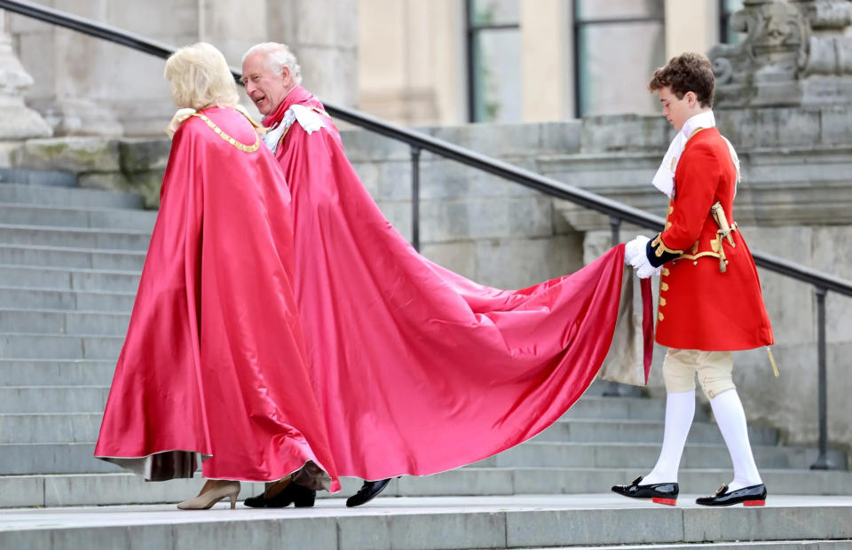 page holding charles and camillas robes on steps on st. pauls