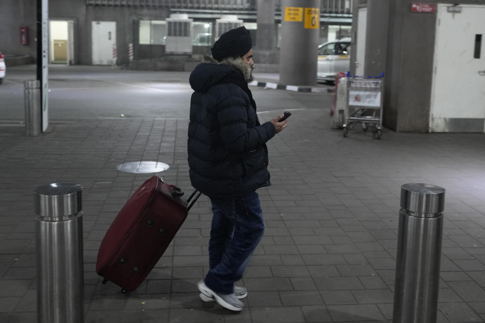 An Indian passenger who travelled in unmarked Legend Airlines A340 from Vatry Airport in France, waits for a taxi at the Chhatrapati Shivaji Maharaj International Airport in Mumbai, India, Tuesday, Dec. 26, 2023. A charter plane that was grounded in France for a human trafficking investigation arrived in India with 276 Indians aboard early Tuesday, authorities said. The passengers had been heading to Nicaragua but were instead blocked inside the Vatry Airport for four days in an exceptional holiday ordeal. (AP Photo/Rafiq Maqbool)