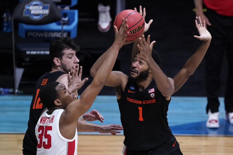 Oregon State forward Maurice Calloo (1) shoots on Houston forward Fabian White Jr. (35) during the first half of an Elite 8 game in the NCAA men's college basketball tournament at Lucas Oil Stadium, Monday, March 29, 2021, in Indianapolis. (AP Photo/Darron Cummings)