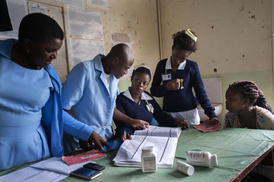 In this photo taken Tuesday Dec. 10, 2019, health officials prepare to vaccine residents of the Malawi village of Migowi, where young children become test subjects for the world's first vaccine against malaria. Babies in three African nations are getting the first and only vaccine for malaria in a pilot program. World health officials want to see how well the vaccine works in Malawi, Ghana and Kenya before recommending its wider use. (AP Photo/Jerome Delay)