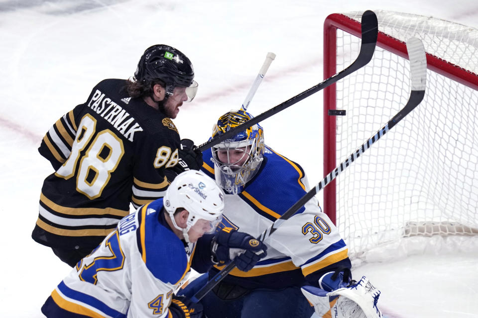 Boston Bruins right wing David Pastrnak (88) tries to tip the puck past St. Louis Blues goaltender Joel Hofer (30) during the first period of an NHL hockey game, Monday, March 11, 2024, in Boston. (AP Photo/Charles Krupa)