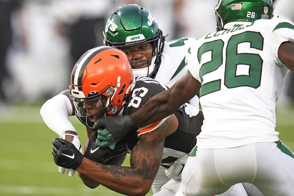 Cleveland Browns wide receiver Cedric Tillman (89) is tackled by New York Jets linebacker Jamien Sherwood (44), and cornerback Brandin Echols (26) during the first half of the Hall of Fame NFL football preseason game Thursday, Aug. 3, 2023, in Canton, Ohio. (AP Photo/Sue Ogrocki)