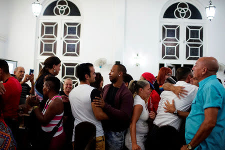 People embrace each other during a mass in a church in Matanzas, Cuba, May 5, 2017. Picture taken on May 5, 2017. REUTERS/Alexandre Meneghini