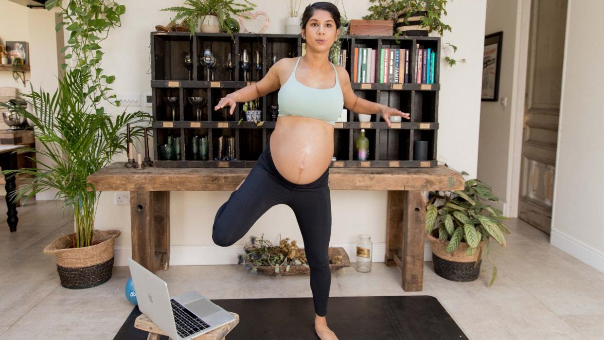  Pregnant woman doing online workout from The Bump Plan. 