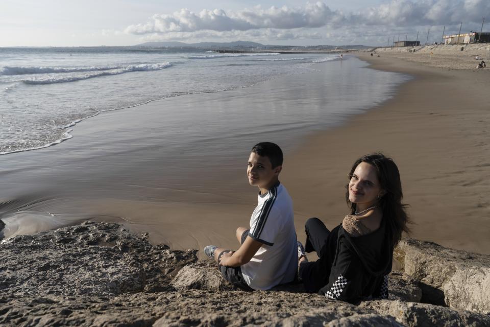 Siblings Sofia Oliveira, 18, and Andre Oliveira, 15, pose for a picture at the beach in Costa da Caparica, south of Lisbon, Wednesday, Sept. 20, 2023. They are two of the six young people from Portugal arguing on Wednesday, Sept. 27, that governments across Europe aren't doing enough to protect people from the harms of climate change at the European Court of Human Rights. (AP Photo/Ana Brigida)