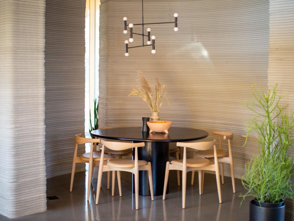 A dining room surrounded by 3D printed walls.