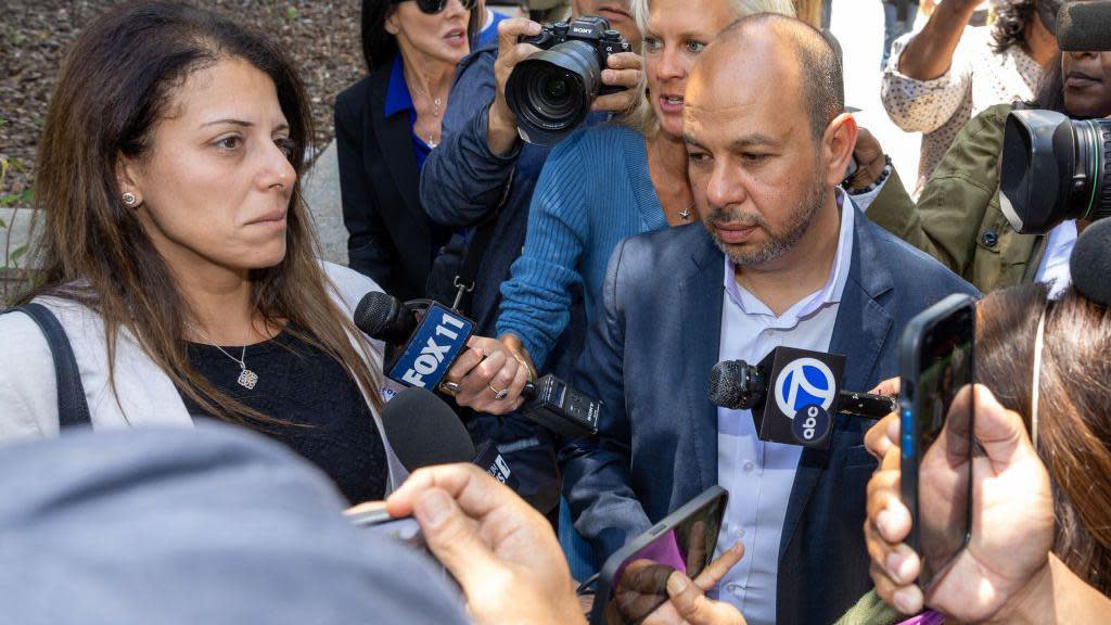 Nancy and Karim Iskander surrounded by journalists