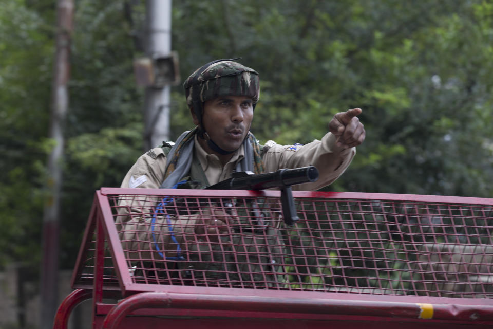 In this Tuesday, Aug. 6, 2019 photo, an Indian Paramilitary soldiers orders a Kashmiri man to turn back near a temporary check point during curfew in Srinagar, Indian controlled Kashmir, Wednesday, Aug. 7, 2019. Authorities in Hindu-majority India clamped a complete shutdown on Kashmir as they scrapped the Muslim-majority state's special status, including exclusive hereditary rights and a separate constitution, and divided it into two territories. (AP Photo/Dar Yasin)