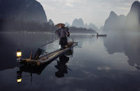 Cormorant fishing is a traditional fishing method in China. Fishermen control the birds by tying a snare near the birdís throat in order to prevent the birds from swallowing larger fish. This technique is practiced in the early morning before sunrise or in the hours before dusk, when fishermen attract the fish with lantern light. (Photo and caption by Andrey Pavlov/National Geographic Traveler Photo Contest) <br> <a href="http://travel.nationalgeographic.com/travel/traveler-magazine/photo-contest/2013/" rel="nofollow noopener" target="_blank" data-ylk="slk:See more and submit;elm:context_link;itc:0;sec:content-canvas" class="link ">See more and submit</a>