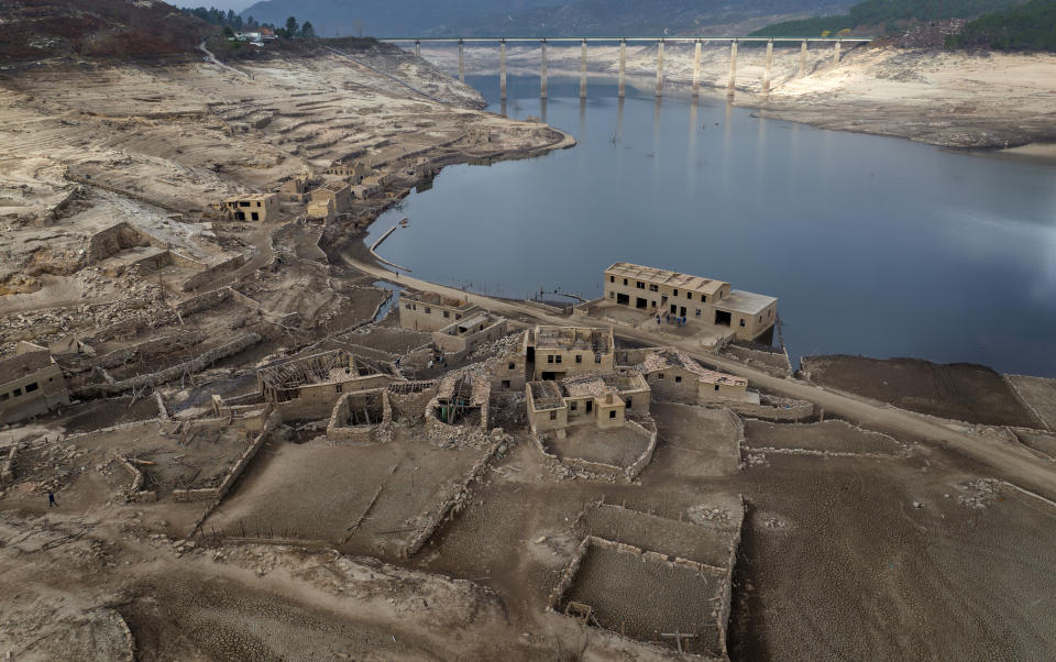 FILE - Parts of the old village of Aceredo, submerged three decades ago when a hydropower dam flooded the valley, which reemerged due to drought at the Lindoso reservoir, in northwestern Spain, Saturday, Feb. 12, 2022. Spain is breathing a sigh of relief as a sharp drop in temperatures is helping firefighters contain wildfires across the country that destroyed tens of thousands of acres of wooded land. (AP Photo/Emilio Morenatti, File)