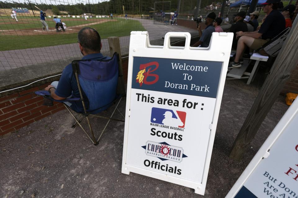 A sign indicates an area behind home plate reserved for Major League scouts during a Cape Cod League baseball game between the Chatham Anglers and the Bourne Braves, Wednesday, July 12, 2023, in Bourne, Mass. For 100 years, the Cape Cod League has given top college players the opportunity to hone their skills and show off for scouts while facing other top talent from around the country. (AP Photo/Michael Dwyer)